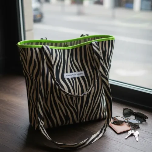 Bolsa de tela con estampado cebra y cremallera verde fluorescente, tote bag moderna de algodón hecha a mano, bolsa sostenible y reutilizable para mujer con estilo urbano.