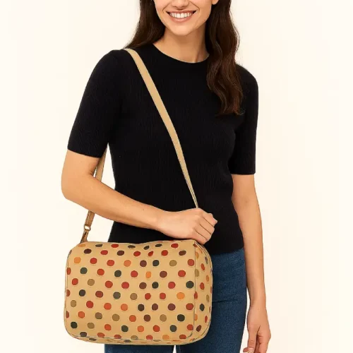 Bolso bandolera de tamaño medio con lunares de colores sobre fondo beige y cremallera frontal. Bolso cruzado de lona para uso diario. Estilo casual, divertido y original.