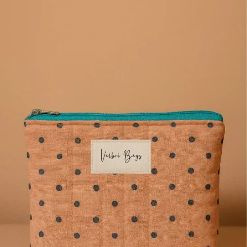 Neceser de tela acolchada color salmón con lunares. Neceser compacto con cremallera turquesa. Estuche de viaje y maquillaje ligero.