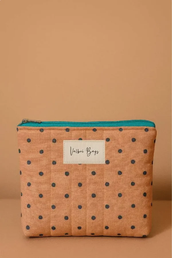 Neceser de tela acolchada color salmón con lunares. Neceser compacto con cremallera turquesa. Estuche de viaje y maquillaje ligero.