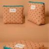Neceser de tela acolchada color salmón con lunares y cremallera turquesa