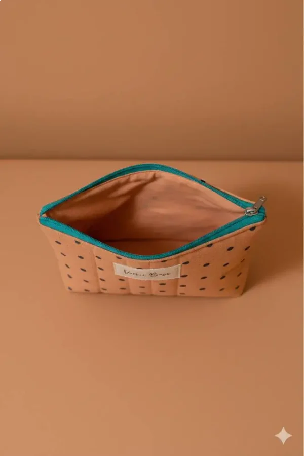 Neceser de tela acolchada color salmón con lunares y cremallera turquesa