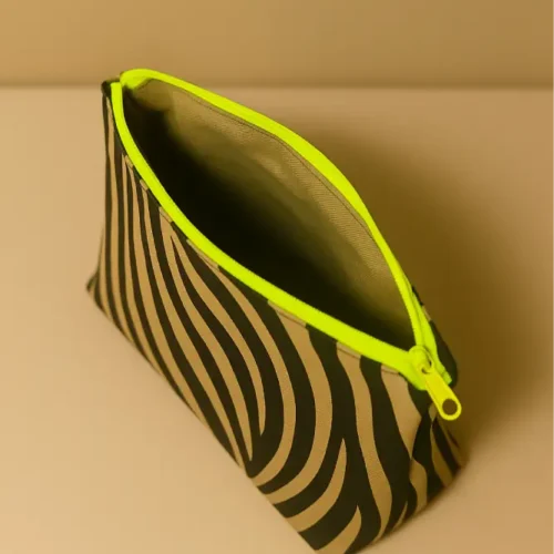 Neceser con estampado animal print de cebra (negro/beige). Neceser de viaje o maquillaje con cremallera neón flúor. Estuche organizador compacto y moderno.