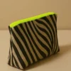 Neceser con estampado animal print de cebra (negro/beige). Neceser de viaje o maquillaje con cremallera neón flúor. Estuche organizador compacto y moderno.