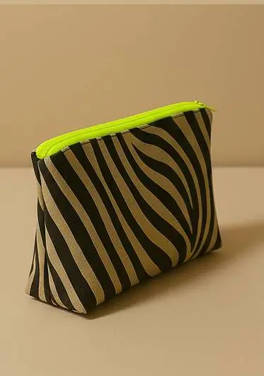 Neceser con estampado animal print de cebra (negro/beige). Neceser de viaje o maquillaje con cremallera neón flúor. Estuche organizador compacto y moderno.